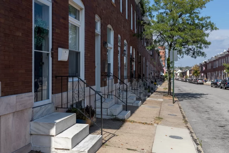 Row of red brick rowhouses with white marble steps in Baltimore, Maryland.